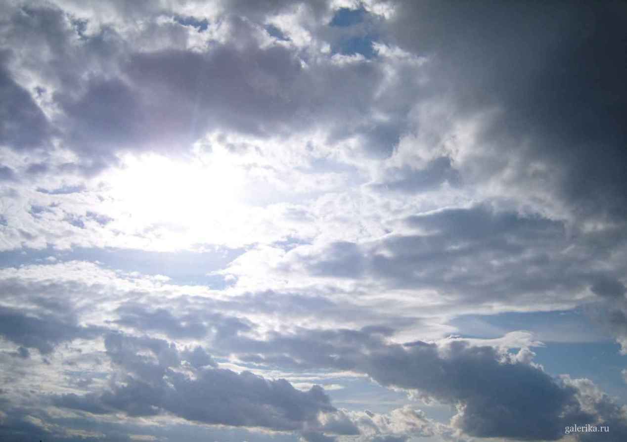 Яркое солнце на фоне множества облаков.